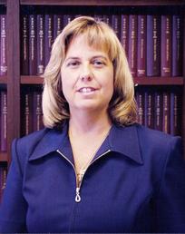 A picture of Mary Jo in front of a bookcase.